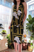 Vintage 2000s black and gold geometric floral halter mini dress with ring detail by Elektra Vintage, shown on a hanger.