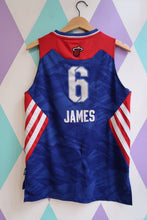 Load image into Gallery viewer, Blue sports jersey with red accents and &#39;James&#39; and number &#39;6&#39; on a colorful geometric background
