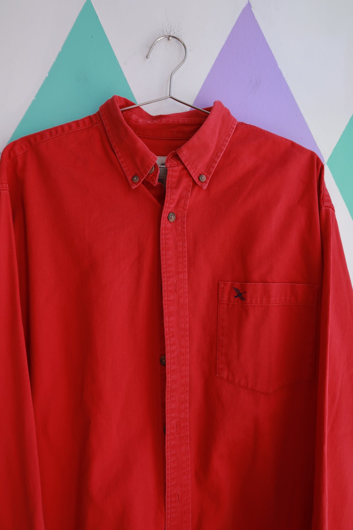 Men's vintage Eddie Bauer red button-down shirt with classic cotton material and oversized fit, styled for a timeless casual look.
