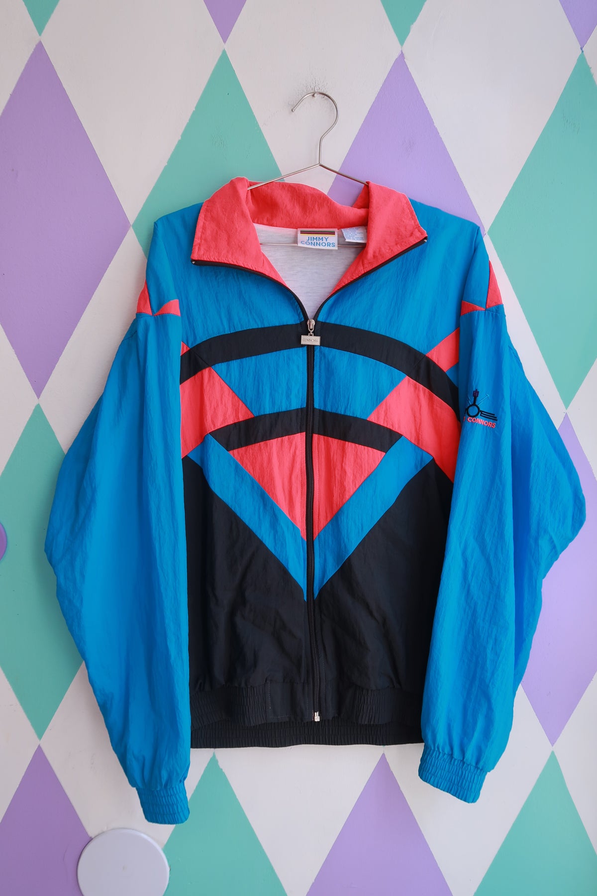 Vintage 90s Jimmy Connors colorblock windbreaker jacket for men, teal, pink, black with zip-up front by Elektra Vintage.