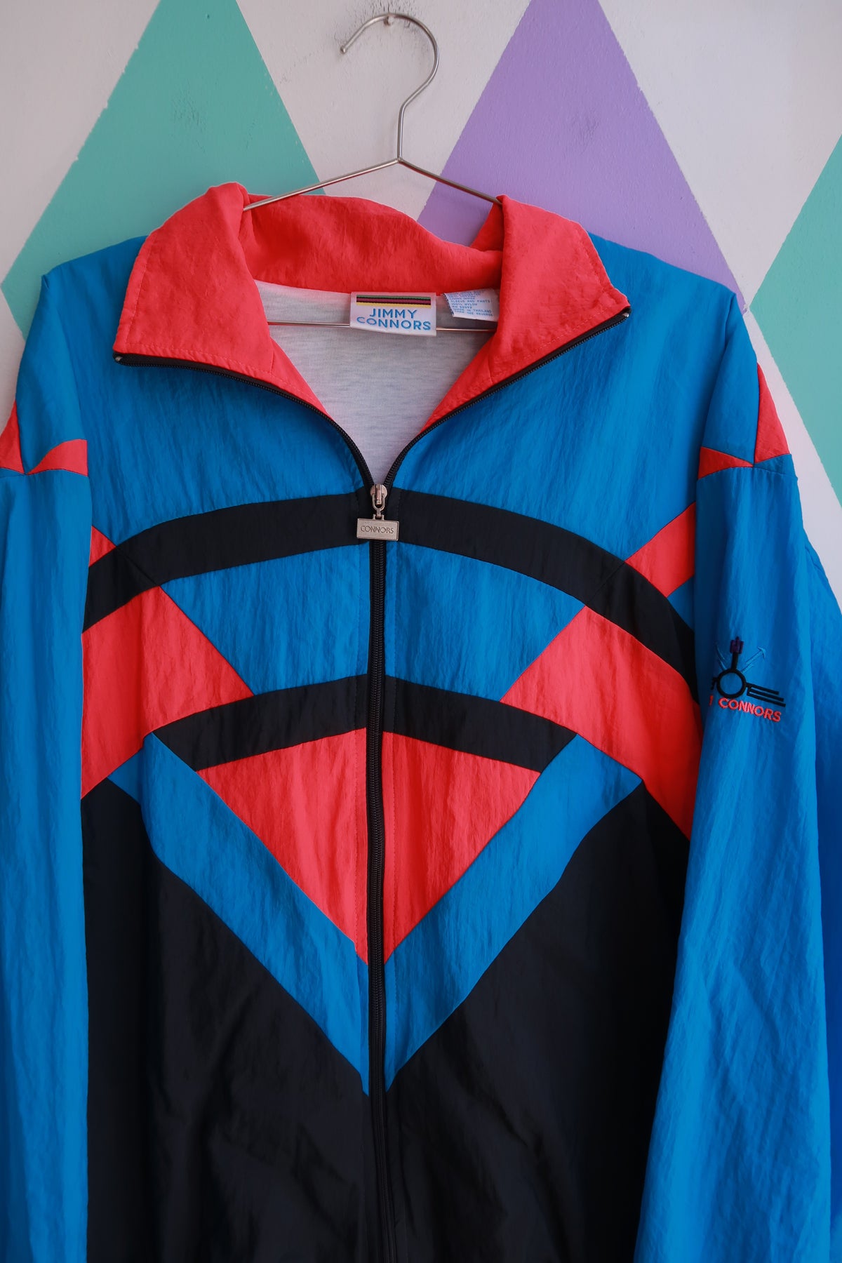 Vintage 90s Jimmy Connors colorblock windbreaker jacket for men, teal, pink, and black zip-up top by Elektra Vintage.