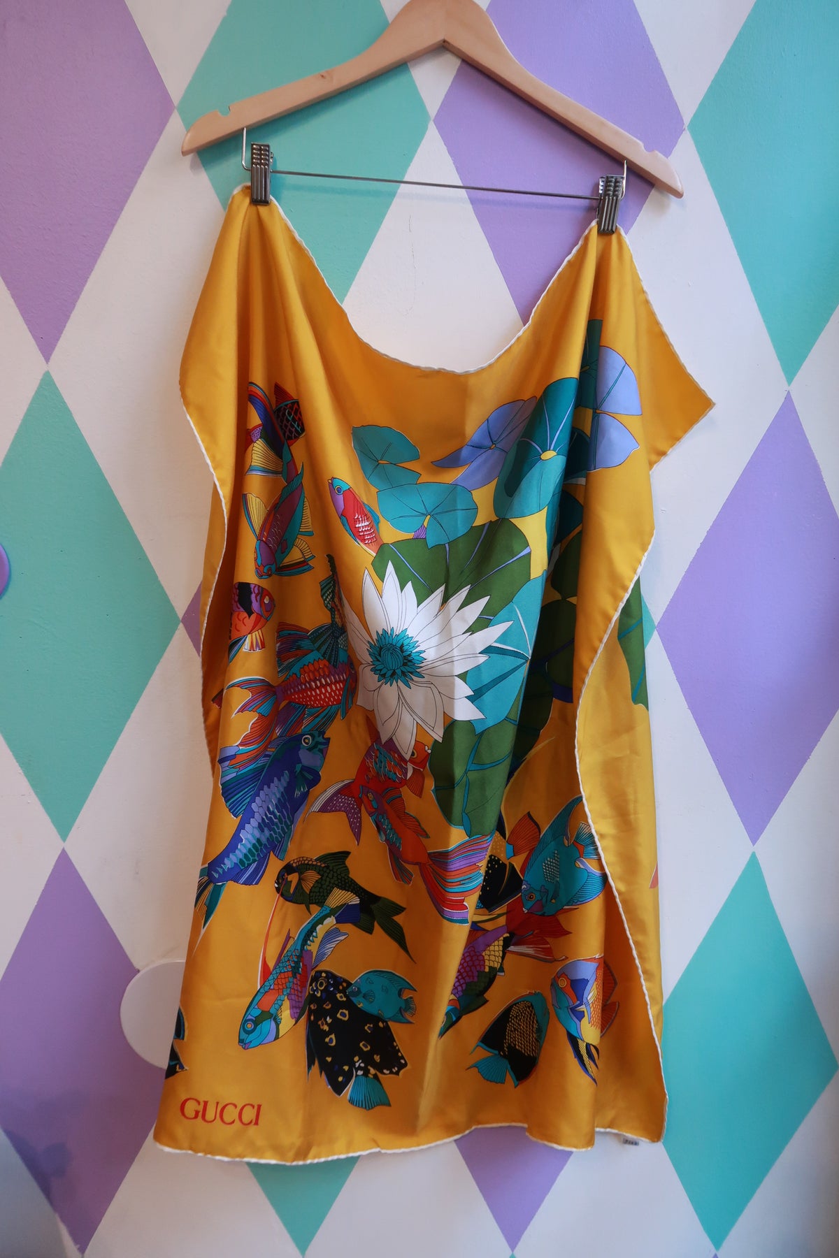Vintage Gucci silk tropical fish scarf in golden yellow and multicolor designer silk, featuring vibrant fish and tropical motifs.