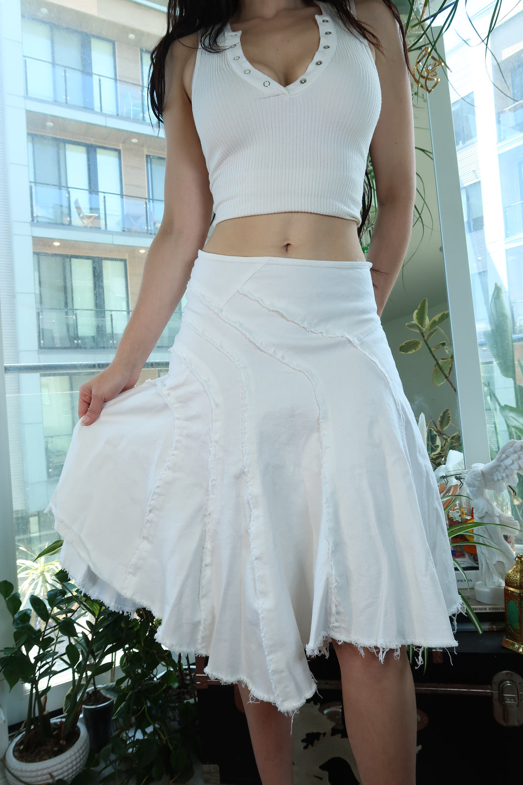White Y2K asymmetrical midi skirt by Elektra Vintage with frayed hem, panel design, and raw seam details.