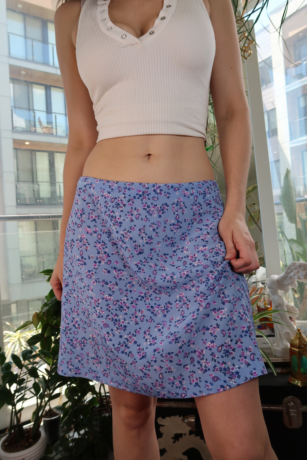 Blue and purple floral mini skirt from Elektra Vintage's Y2K vintage collection, featuring a fitted waistband and vibrant pattern.
