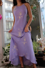 Load image into Gallery viewer, Person wearing a long, light purple dress with floral patterns indoors.
