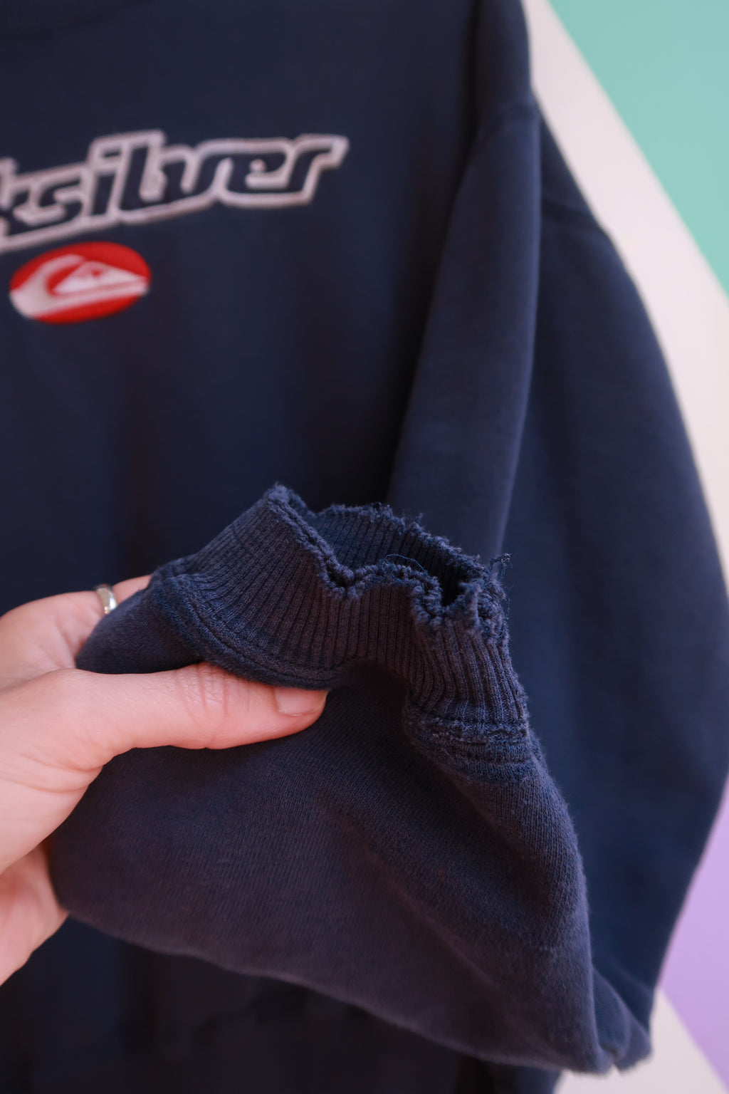 Vintage 2000s Quiksilver embroidered logo crewneck sweatshirt in navy, featuring classic surf brand embroidery and ribbed cuffs.