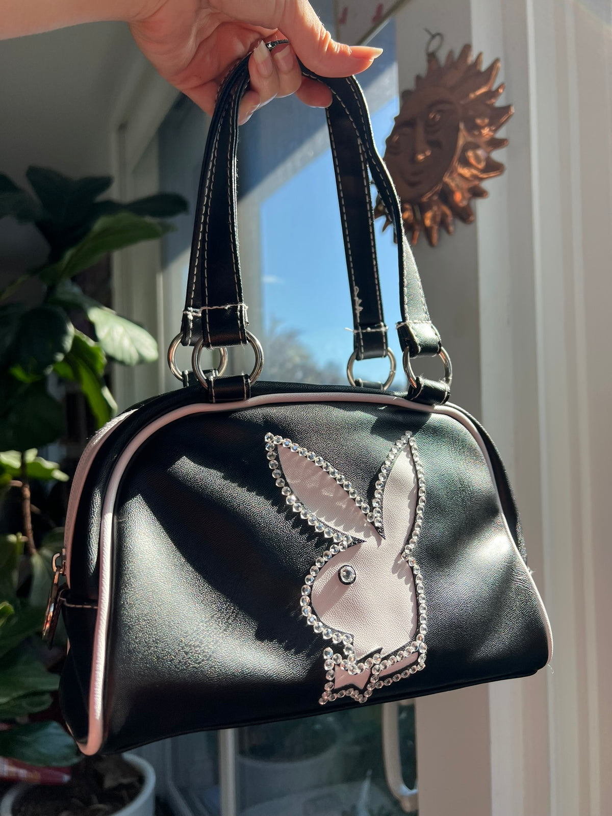 Black bowler bag from the 2000s Vintage Playboy collection by Elektra Vintage, featuring a classic design and sturdy handles.