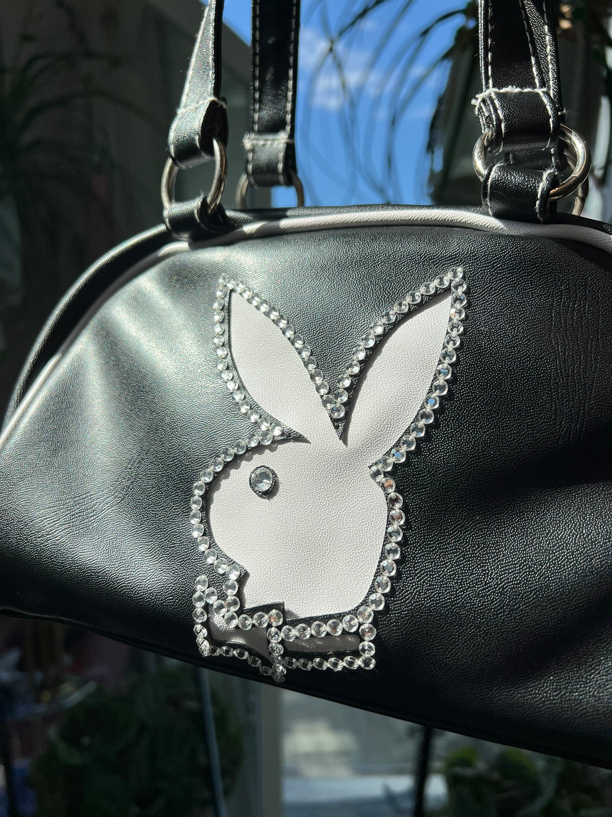 Vintage black bowler bag by Elektra Vintage, 2000s Playboy-inspired design with sleek leather and classic bag features.