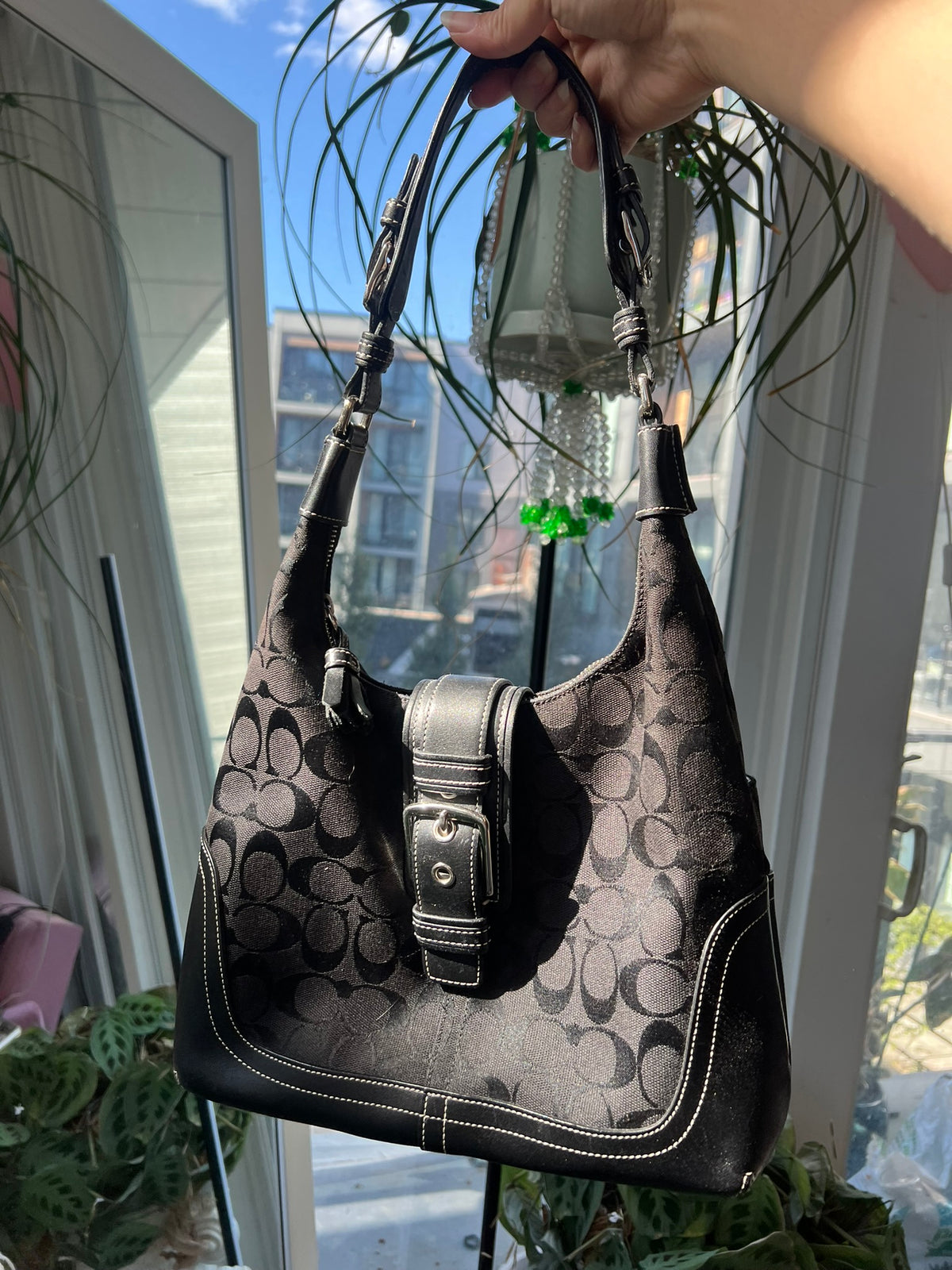 Black leather Hamilton Hobo shoulder bag by Coach, featuring a sleek design and spacious interior for everyday use.