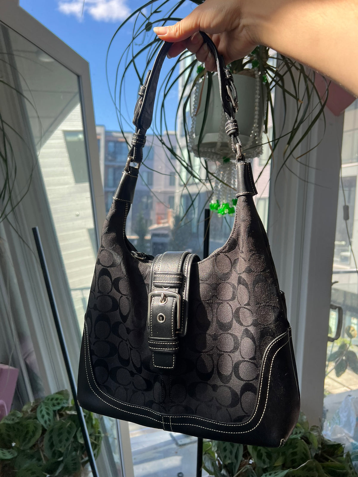 Black leather Hamilton hobo shoulder bag by Coach, featuring a sleek design and spacious interior, from Elektra Vintage.